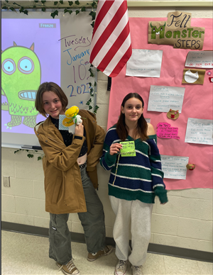 students hold their sewing projects 
